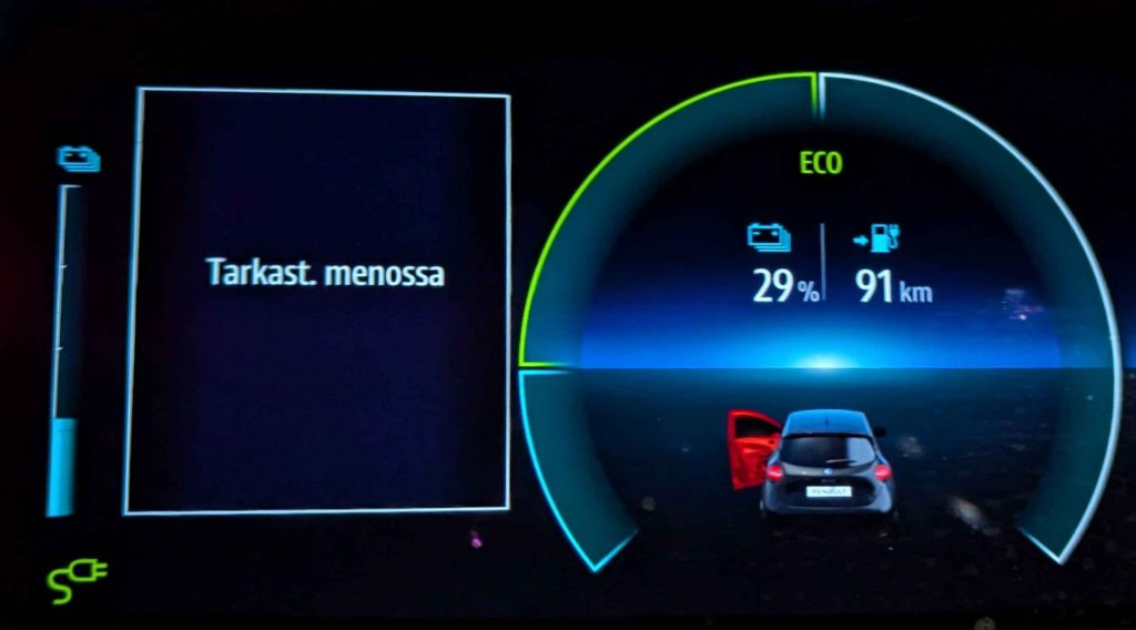 Sähköauton näyttöpaneeli. 29% latausta, 91 km kantamaa. Latauskaapelisignaali palaa, ja isossa ruudussa lukee "Tarkast. menossa"